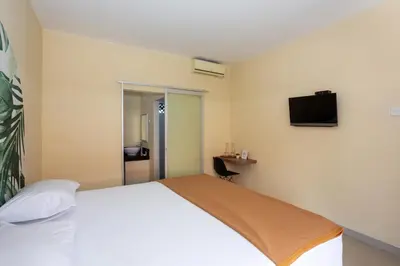 a bedroom with a bed and a television on the wall at Cove Kanaya in Denpasar