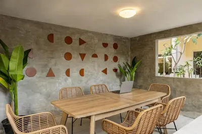 a dining room with a wooden table and chairs at Cove Kanaya in Denpasar