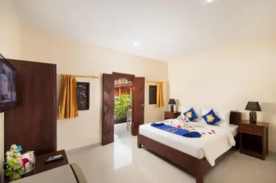 a bedroom with a bed and a television in it at Lumbung Sari Hotel Legian in Legian
