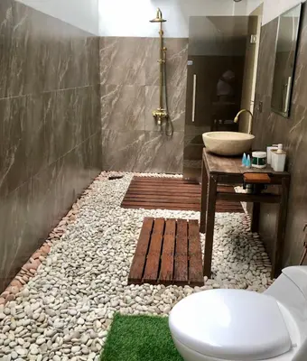 a bathroom with a toilet and a sink and a counter at Villa Denira in Nusa Dua