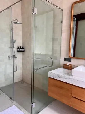 a glass shower in a bathroom with a sink at T villa in Seminyak
