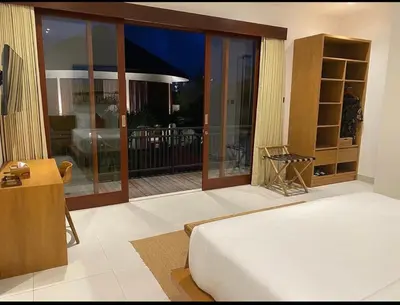 a bedroom with a bed and a sliding glass door at T villa in Seminyak