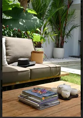 a coffee table with a couch and a pile of books at T villa in Seminyak