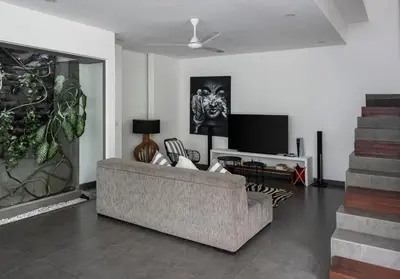 a living room with a couch and a tv at Villa Alopa 1 in Seminyak