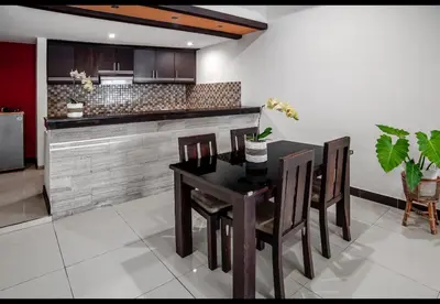a kitchen with a table and chairs and a counter at Pondok Arya Kuta Villas by Kamara in Kuta