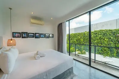 a bedroom with a white bed and a large window at Bali Townhouse 1 - Amazing 2BR Villa w/pool - Perfect Location in Canggu