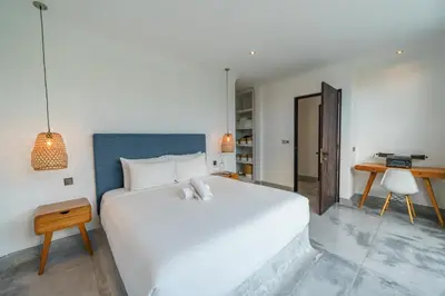 a white bedroom with a large white bed and a desk at Bali Townhouse 1 - Amazing 2BR Villa w/pool - Perfect Location in Canggu