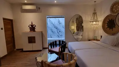 a bedroom with a bed and a chair and a mirror at Villa Loba in Seminyak