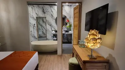a bathroom with a bath tub and a television at Villa Loba in Seminyak