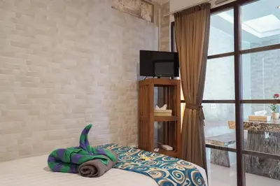 a green dinosaur pillow on a bed in a bedroom at Villa Indalia in Seminyak
