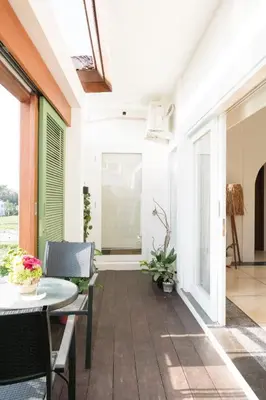 a porch with a table and chairs and a window at DORALICE by a Paddy Field in Kerobokan