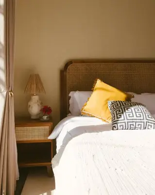 a bed with yellow and white pillows and a lamp at DORALICE by a Paddy Field in Kerobokan