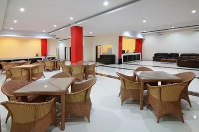 a restaurant with tables and chairs in a room at Alkyfa Hotel Bali in Denpasar