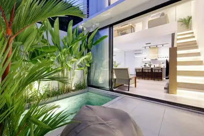 an indoor swimming pool in a house with plants at The Oasis Smart Villa in Canggu
