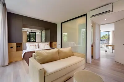 a bedroom with a bed and a couch in a room at The Oasis Smart Villa in Canggu