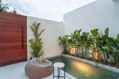 a balcony with a swimming pool and some plants at The Oasis Smart Villa in Canggu