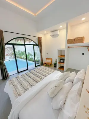 a large white bed in a room with a large window at Stella Moon Villa Bali in Kerobokan
