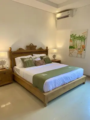 a bedroom with a large bed with a wooden frame at Villa Solas Legian in Legian