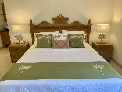 a bedroom with a large bed with two night stands at Villa Solas Legian in Legian