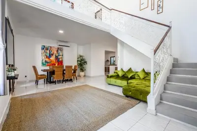 a living room with a staircase and a green couch at Villa Sky View - Seminyak in Seminyak