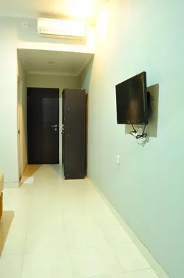 a hallway with a flat screen tv on a wall at Amerta Home Stay Bali in Denpasar