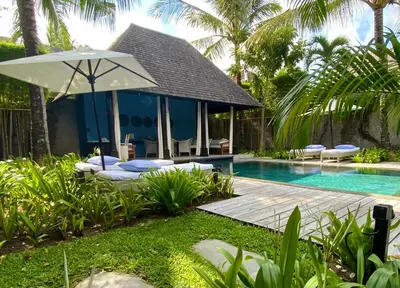 a villa with a swimming pool and an umbrella at Villa Samuan in Seminyak