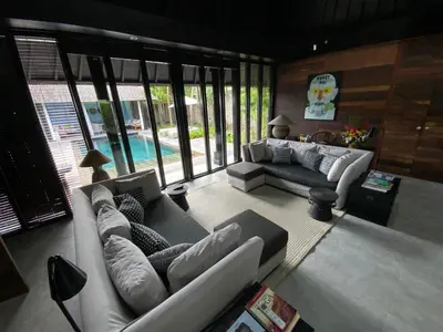 a living room with couches and a pool at Villa Samuan in Seminyak