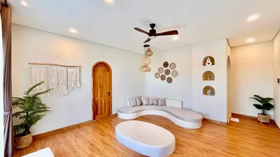 a living room with a couch and a ceiling fan at The BALIem Villa in Jimbaran