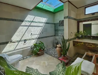 a bathroom with a toilet and a sink and plants at The Chand Villa - A Hidden Gem in Petitenget in Seminyak