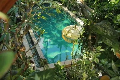 a swimming pool in a garden with trees at The Chand Villa - A Hidden Gem in Petitenget in Seminyak