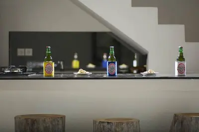 three bottles of beer sitting on a counter with stools at Yoga Villa in Seminyak