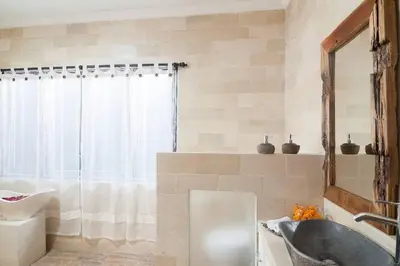 a bathroom with a tub and a sink and a mirror at Selog Villa 2 in Seminyak