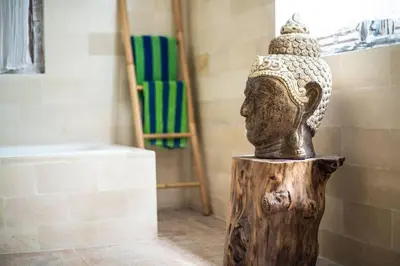 a statue of a head sitting on top of a stump at Selog Villa 2 in Seminyak