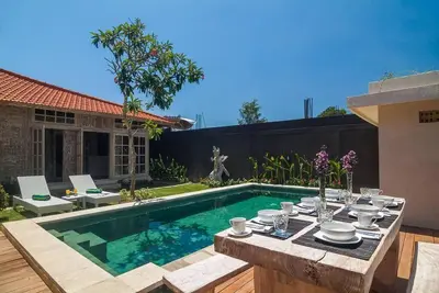 a backyard with a table and a swimming pool at Selog Villa 2 in Seminyak