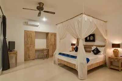 a bedroom with a bed with a canopy at Selog Villa 4 in Seminyak