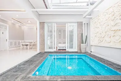 a swimming pool in the middle of a room with a table at Desa Residence Kerobokan in Kerobokan