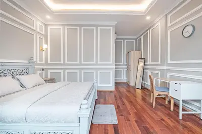 a white bedroom with a bed and a desk at Desa Residence Kerobokan in Kerobokan