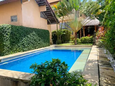 a swimming pool in front of a house at Villa Kinandari Bukit Jimbaran in Jimbaran