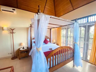 a bedroom with a bed with a canopy at Villa Kinandari Bukit Jimbaran in Jimbaran