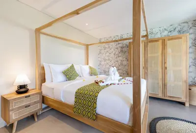 a bedroom with a large white bed and a dresser at Villa ElyOs Canggu by Nagisa Bali in Canggu