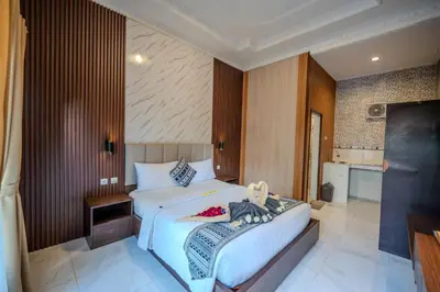 a bedroom with a bed with a teddy bear on it at Wana Kubu Homestay in Kuta