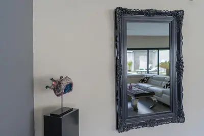 a mirror hanging on a wall next to a couch at LOTUS - Bali Invest Club in Kerobokan