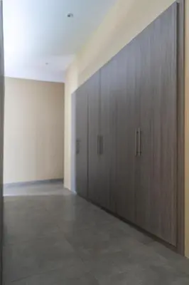 an empty room with wooden doors in a building at LOTUS - Bali Invest Club in Kerobokan