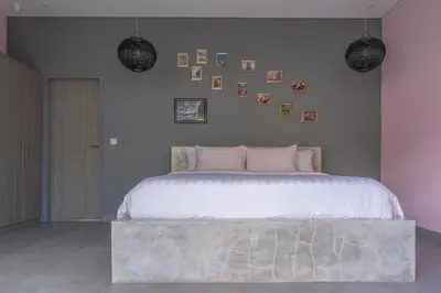 a bedroom with a large bed and pictures on the wall at LOTUS - Bali Invest Club in Kerobokan