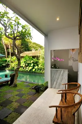 a room with two chairs and a tree at Room & Vespa 1 - Stay Central Seminyak Near Beach in Seminyak