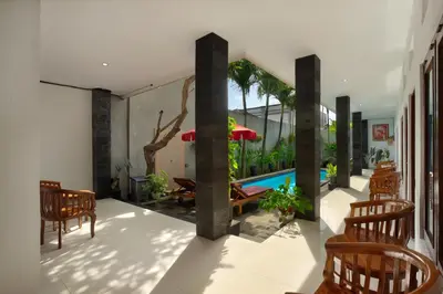 a living room with a swimming pool and chairs at Graha Wedha Suite Kuta by kamara in Kuta