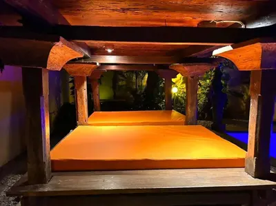 a wooden chair with an orange bed underneath a table at kuta 5BR private villa pool ,near airport, in Kuta