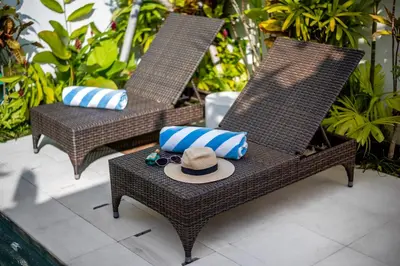 two wicker chairs with pillows and a hat on a table at Villa Balik II Seminyak in Seminyak