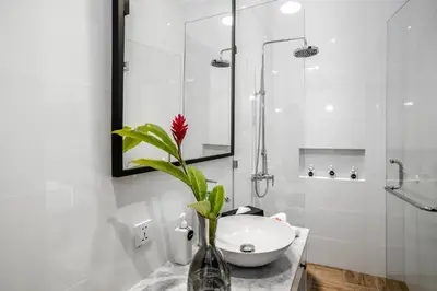 a bathroom with a sink and a vase with a flower in it at Villa Balik II Seminyak in Seminyak