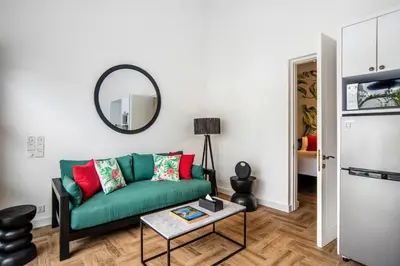 a living room with a green couch and a mirror at Villa Balik II Seminyak in Seminyak